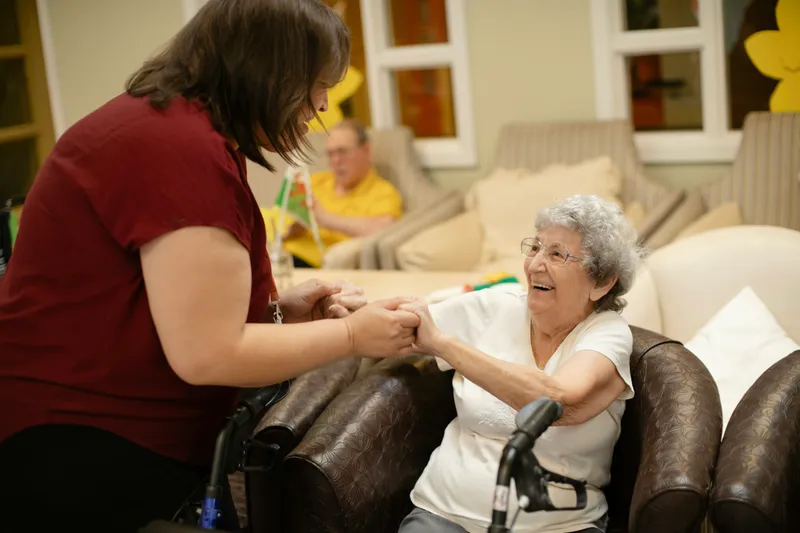 Caregiver assisting an older woman with a walker
